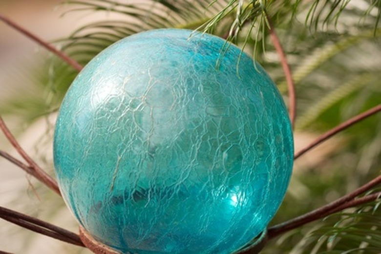 A shiny blue gazing ball sitting in a garden.