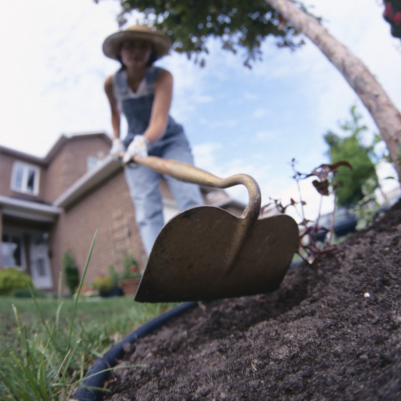 Woman using hoe in soil