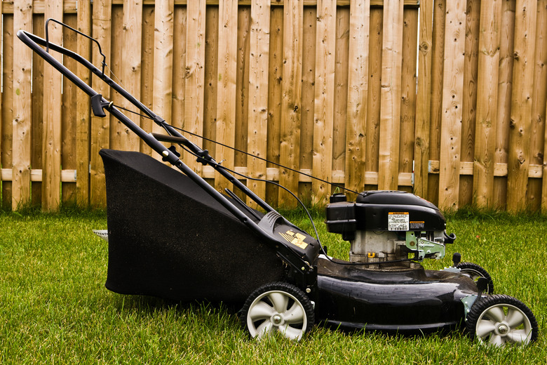 Power lawnmower in yard with fence