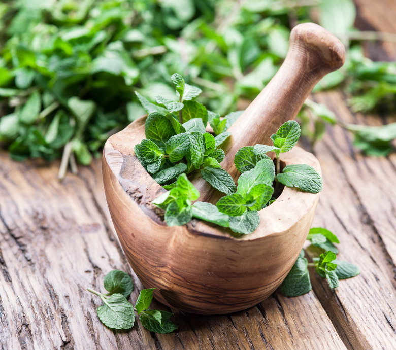 Fresh mint, wooden mortar and pestle.