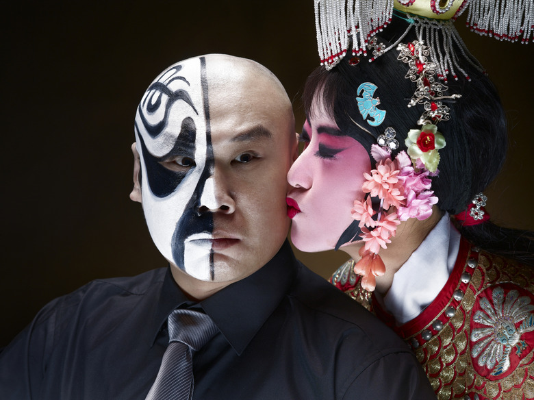 Female Chinese opera singer kissing male actor 