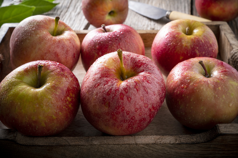 Red apples in a wooden crate.