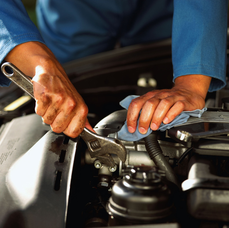 Hands of mechanic fixing engine